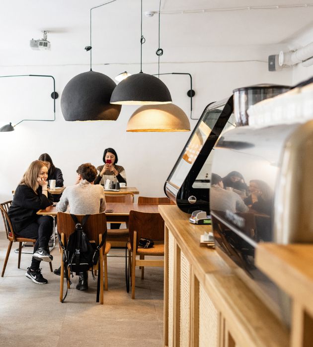 Interior de cafetería con personas en las mesas